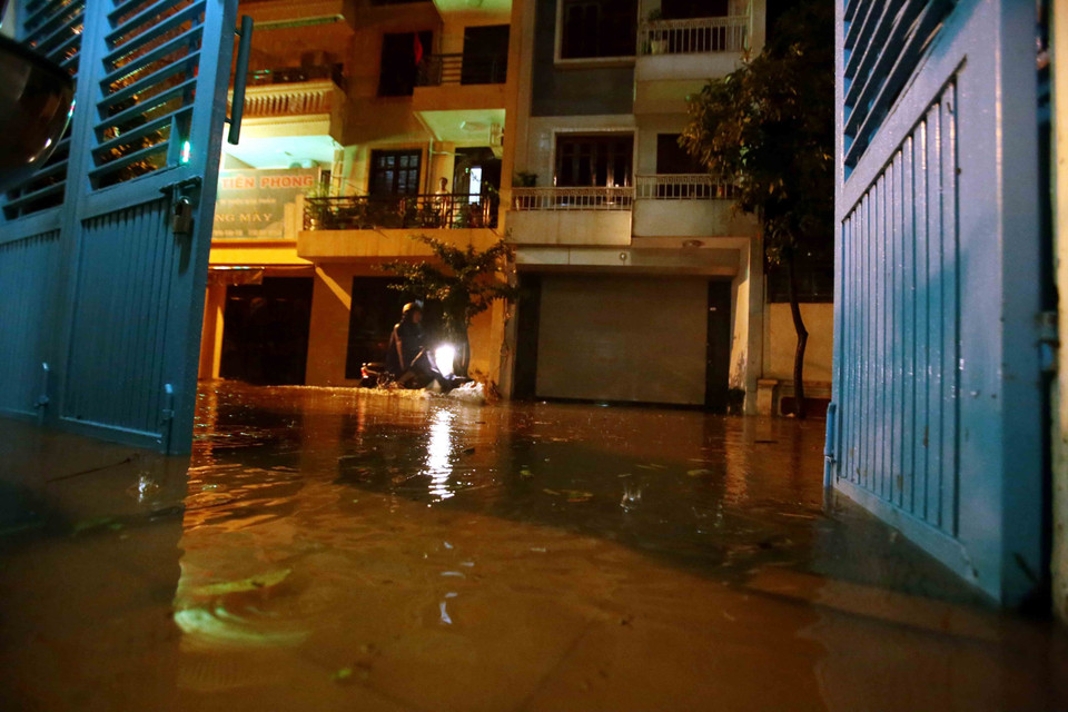 Mưa lớn khiến nước tràn ngập vào các hộ dân tại khu đô thị Văn Quán, Quận Hà Đông. (Ảnh: Phạm Kiên/TTXVN)
