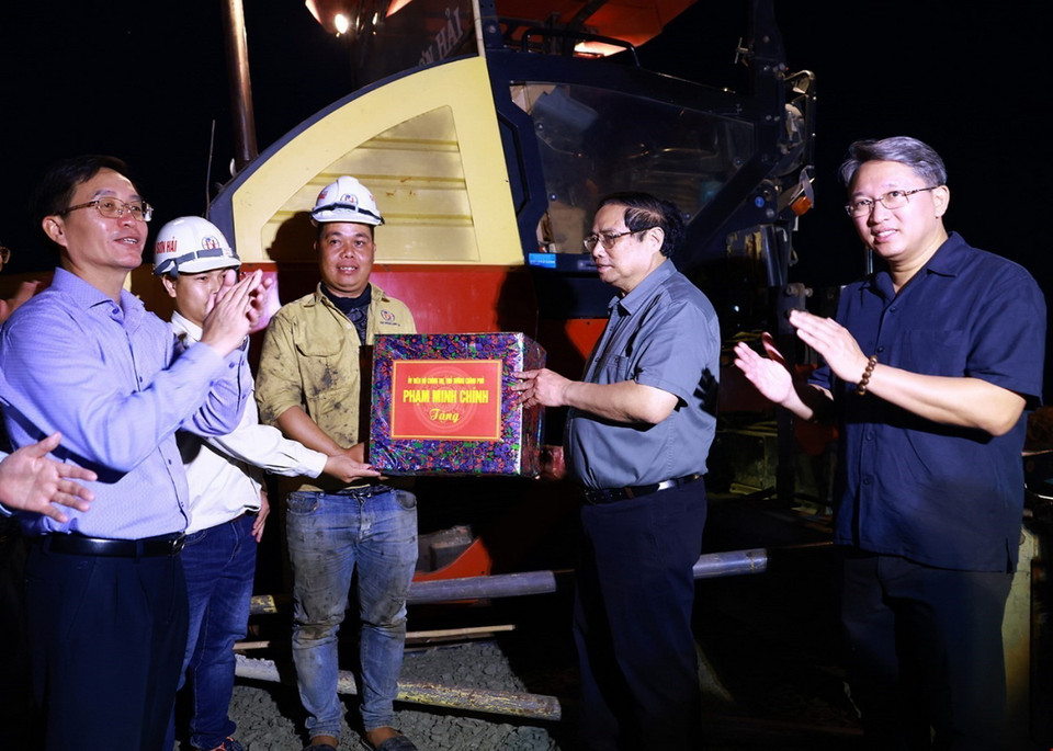 Thủ tướng Phạm Minh Chính tặng quà động viên công nhân thi công đường bộ cao tốc Khánh Hòa-Buôn Ma Thuột. (Ảnh: Dương Giang/TTXVN)