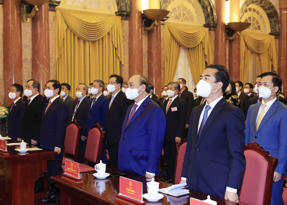 Chiều 14/12/2021, tại Phủ Chủ tịch, Chủ tịch nước Nguyễn Xuân Phúc trao Quyết định phong hàm Đại sứ và gặp mặt các đại sứ, trưởng cơ quan đại diện Việt Nam tại nước ngoài nhân dịp về dự Hội nghị Đối ngoại toàn quốc, Hội nghị Ngoại giao 31 và Hội nghị Ngoại vụ toàn quốc lần thứ 20. Trong ảnh: Chủ tịch nước Nguyễn Xuân Phúc và các đại biểu thực hiện nghi lễ chào cờ. (Ảnh: Thống Nhất/TTXVN)