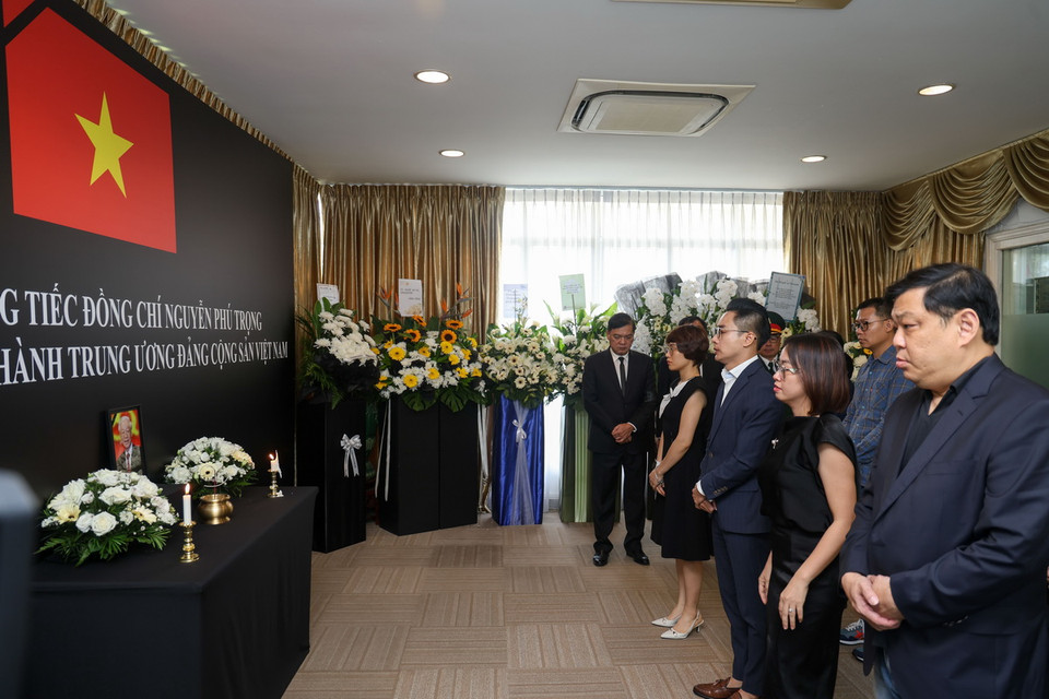 Đại diện Công ty FPT tại Singapore kính viếng Tổng Bí thư Nguyễn Phú Trọng. (Ảnh: Lê Dương/TTXVN)