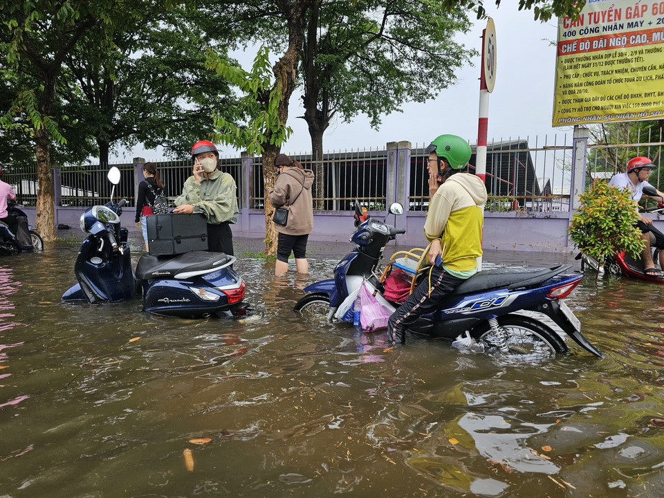 Nước ngập sâu khiến nhiều xe máy không thể di chuyển được trong Khu công nghiệp Giao Long. (Ảnh: Huỳnh Phúc Hậu/TTXVN)