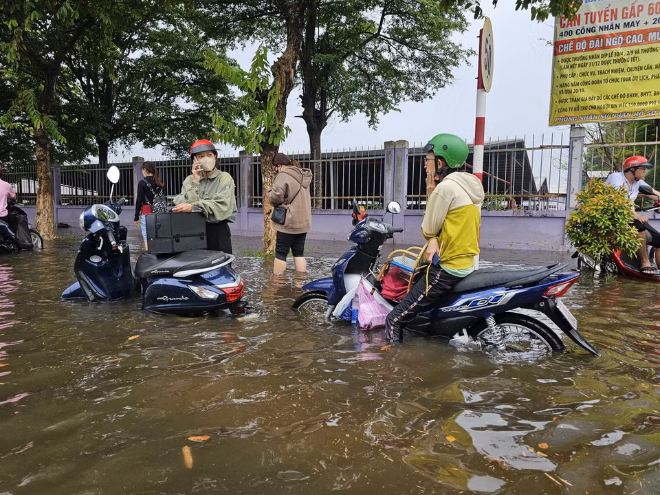 Nước ngập sâu khiến nhiều xe máy không thể di chuyển được trong Khu công nghiệp Giao Long. (Ảnh: Huỳnh Phúc Hậu/TTXVN)