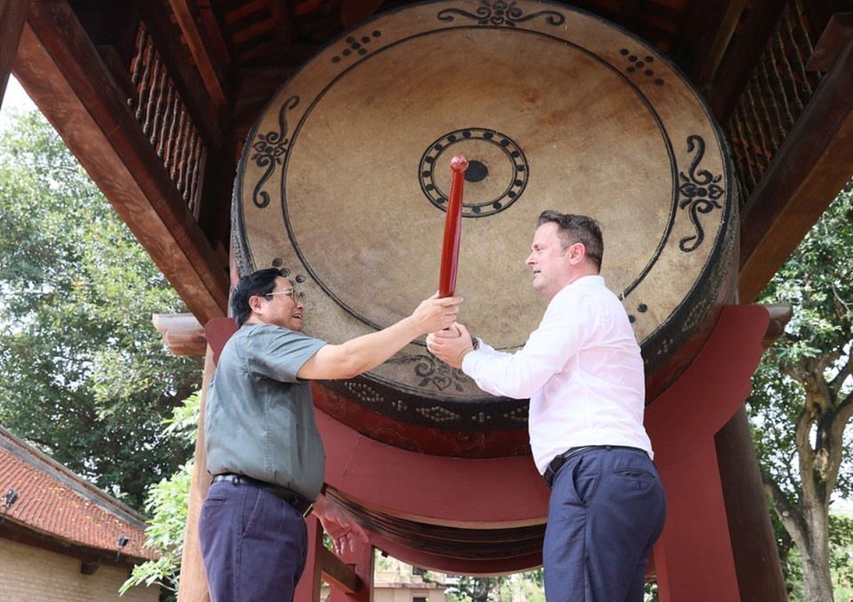 Thủ tướng Phạm Minh Chính và Thủ tướng Đại Công quốc Luxembourg Xavier Bettel cùng đánh trống tại Di tích Quốc gia đặc biệt Văn Miếu-Quốc Tử Giám. (Ảnh: Dương Giang/TTXVN)