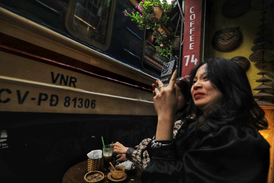 Một du khách ghi lại bức hình khi tàu chạy ngay sát mình. (Ảnh: Tuấn Anh/TTXVN)