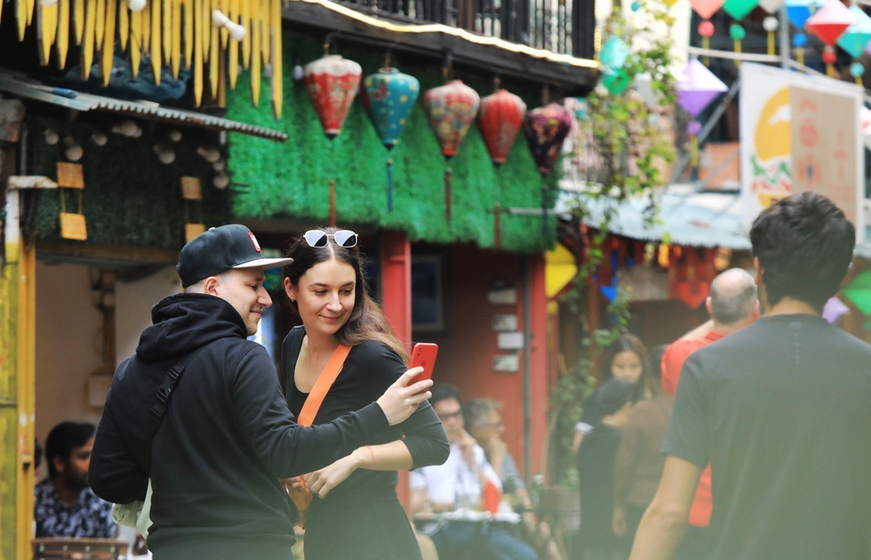 Du khách nước ngoài thích thú ghi lại những bức ảnh kỷ niệm ngay trên đường tàu. (Ảnh: Tuấn Anh/TTXVN)