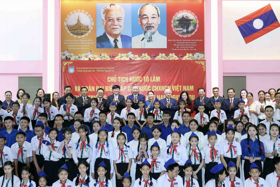Chủ tịch nước Tô Lâm và các đại biểu chụp ảnh chung với thầy cô giáo và học sinh Trường song ngữ Lào-Việt Nam. (Ảnh: Nhan Sáng/TTXVN)