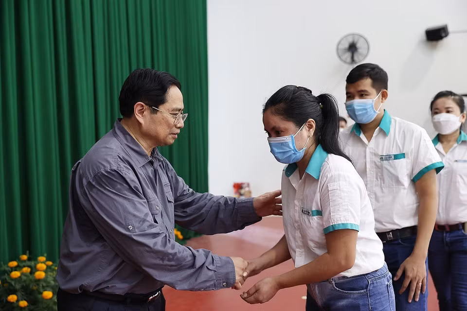 Công nhân có hoàn cảnh khó khăn Khu công nghiệp Hòa Phú nhận quà Tết. (Ảnh: Dương Giang/TTXVN)