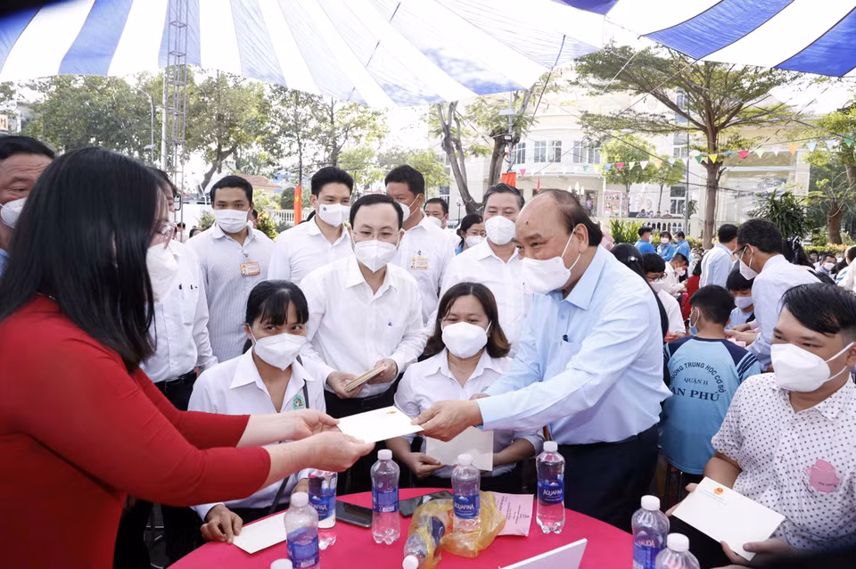 Chủ tịch nước trao qua Tết. (Ảnh: Thống Nhất/TTXVN)