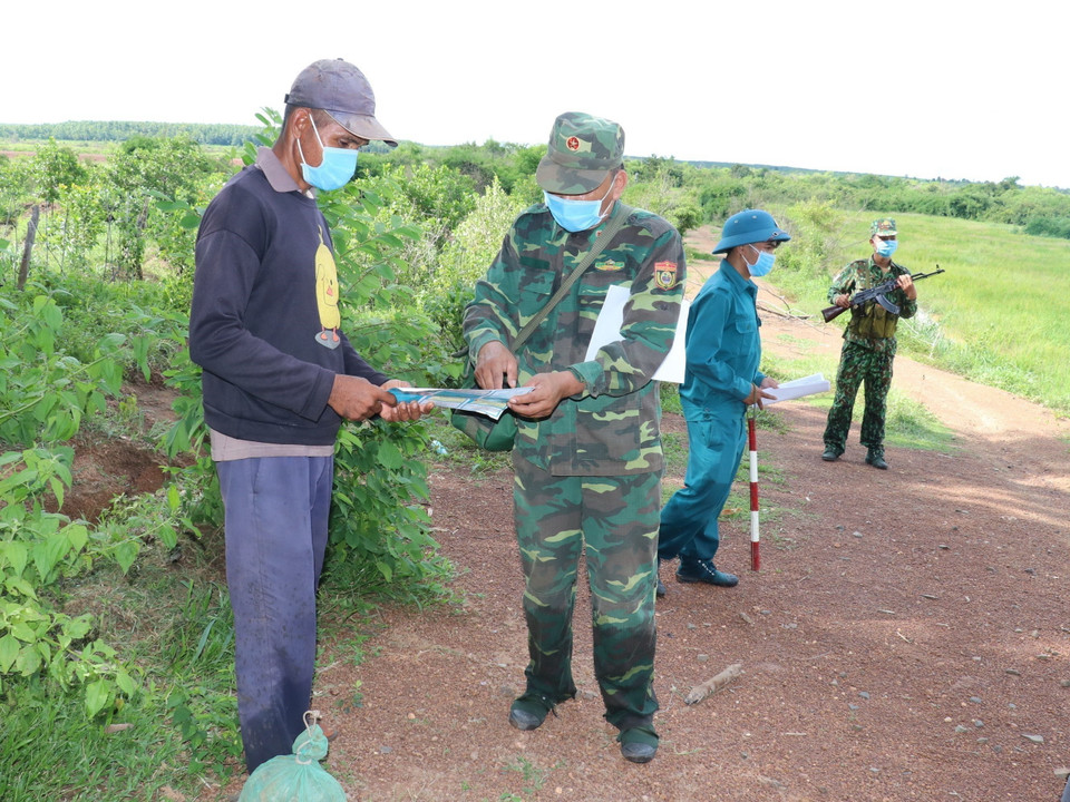 Tổ tuần tra biên giới và kiểm soát dịch bệnh COVID-19, thuộc Đồn biên phòng Lộc An (Bình Phước) tuyên truyền cho người dân về quy chế biên giới. (Ảnh: Sỹ Tuyên/TTXVN)