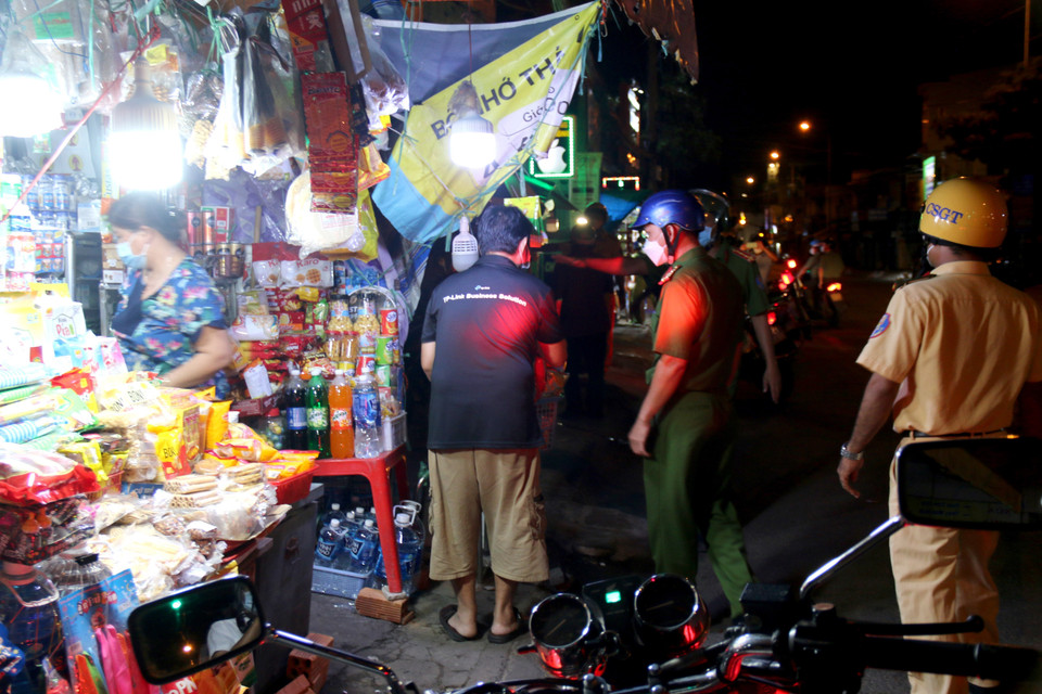 Lực lượng chức năng kiểm tra nhắc nhở các hộ kinh doanh dừng hoạt động theo quy định từ 19 giờ ngày hôm trước đến 5 giờ sáng ngày hôm sau. (Ảnh: Nguyễn Thanh/TTXVN)