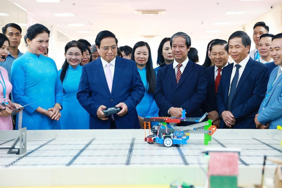 Thủ tướng Phạm Minh Chính trải nghiệm điều khiển robot tại Học viện Phụ nữ Việt Nam. (Ảnh: Dương Giang/TTXVN)