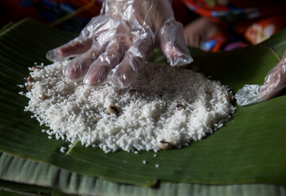 Sản phẩm bánh tét Phước Hòa được cung cấp cho thị trường trong tỉnh, cũng như các tỉnh thành lân cận. Năm nay, bánh tét Phước Hòa có giá bán sỉ từ 10.000-40.000 đồng/đòn, tùy theo kích cỡ. Trong ảnh: Trải gạo nếp để gói bánh tét. (Ảnh: Hồng Đạt/TTXVN)