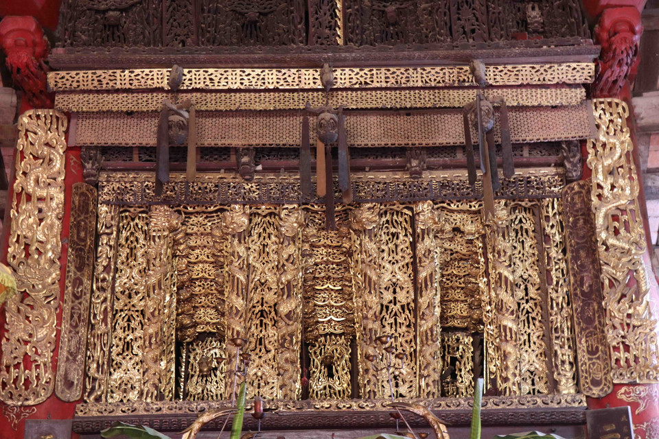 Mỗi tầng trang trí các chủ đề khác nhau, phân ra các tầng, mảng riêng nhưng cả năm tầng lại có mối liên kết hài hòa, uyển chuyển, mang vẻ đẹp nhân sinh, đề cao cuộc sống con người lao động và tinh thần dân chủ cũng như khát vọng phồn thực, mong muốn sự sinh sôi nảy nở của con người trong cuộc sống… Trong ảnh: Tầng thứ 4 bức Cửa võng đạt đến trình độ cao của nghệ thuật sơn son thiếp vàng. (Ảnh: Thanh Thương/TTXVN)