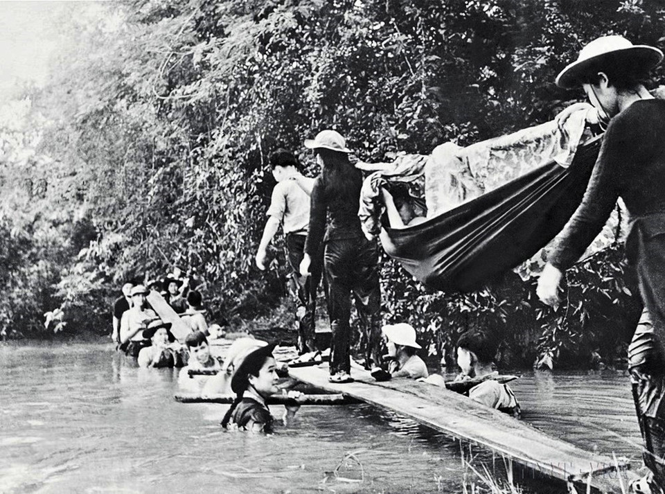 Bức ảnh “Cầu người” của phóng viên TTXVN Phạm Văn Thính ghi lại sinh động hình ảnh những thanh niên xung phong ngâm mình dưới nước làm trụ để đỡ các tấm ván, tạo thành chiếc cầu để chuyển thương binh qua suối Nhum, thuộc Chiến khu D, huyện Dương Minh Châu, tỉnh Tây Ninh, trong cuộc Tổng tiến công và nổi dậy Xuân Mậu Thân 1968. (Ảnh: Phạm Văn Thính/TTXVN)