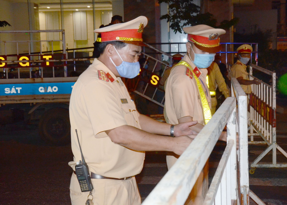 Đúng 23 giờ 30 phút tối 27/7, lực lượng chức năng bắt đầu triển khai công tác phong tỏa các tuyến phố xung quanh 3 bệnh viện có liên quan đến các ca nhiễm COVID-19. (Ảnh: Quốc Dũng/TTXVN)