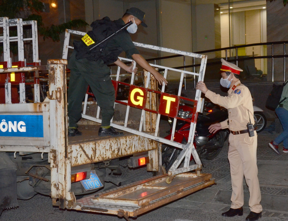 Đúng 23 giờ 30 phút tối 27/7, lực lượng chức năng bắt đầu triển khai công tác phong tỏa các tuyến phố xung quanh 3 bệnh viện có liên quan đến các ca nhiễm COVID-19. (Ảnh: Quốc Dũng/TTXVN)