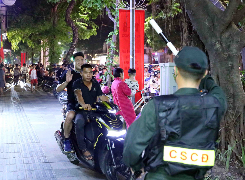 Lực lượng Cảnh sát Cơ động thuộc Tổ công tác Y4/141 dừng xe kiểm tra và xừ phạt 1 trường hợp vi phạm trật tự an toàn giao thông tại tuyến phố Hàng Bài-Trần Hưng Đạo tối 2/9. (Ảnh: Phạm Kiên/TTXVN)