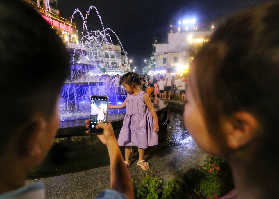 Người dân lưu lại hình ảnh lưu niệm trên Phố đi bộ Hồ Gươm. (Ảnh: Tuấn Đức/TTXVN)