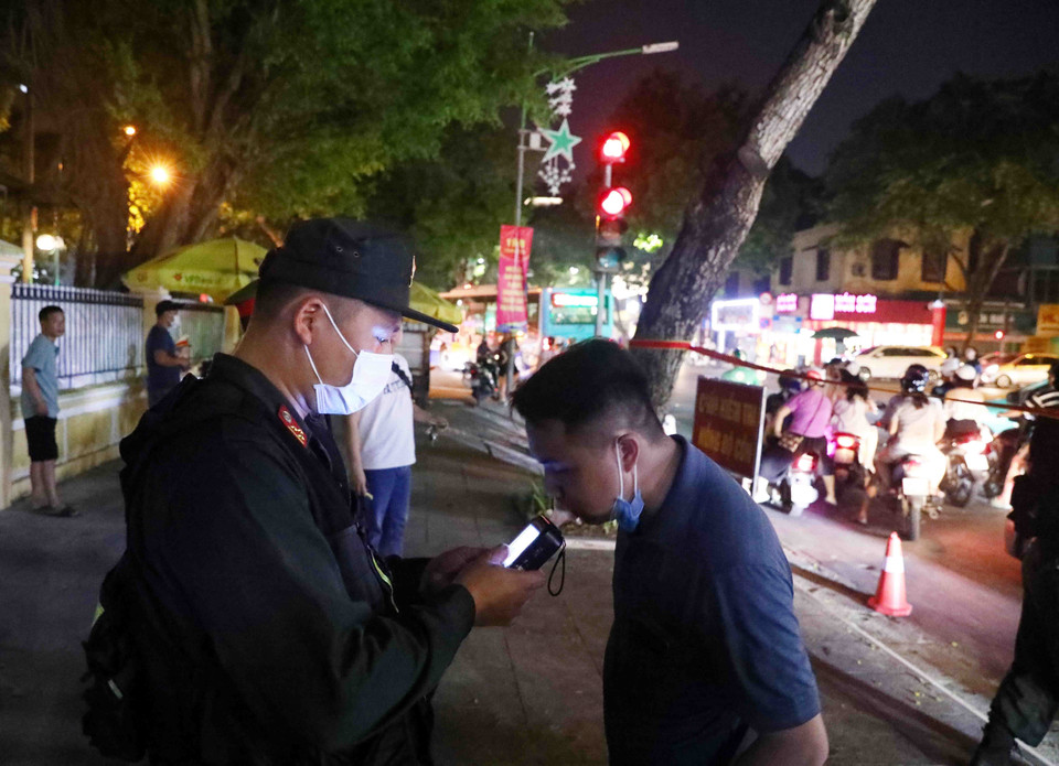 Tổ công tác Y4/141 kiểm tra nồng độ cồn đối với 1 trường hợp tham gia giao thông tại tuyến phố Hàng Bài-Trần Hưng Đạo. (Ảnh: Phạm Kiên/TTXVN)