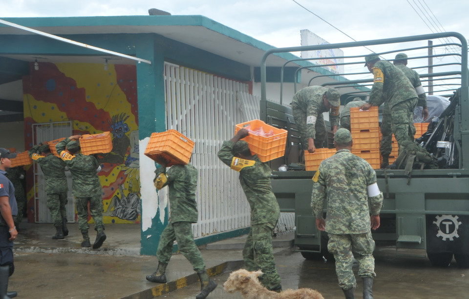  Cảnh sát và quân đội được huy động giúp đỡ người dân khắc phục hậu quả. (Ảnh: Việt Hùng/Vietnam+)