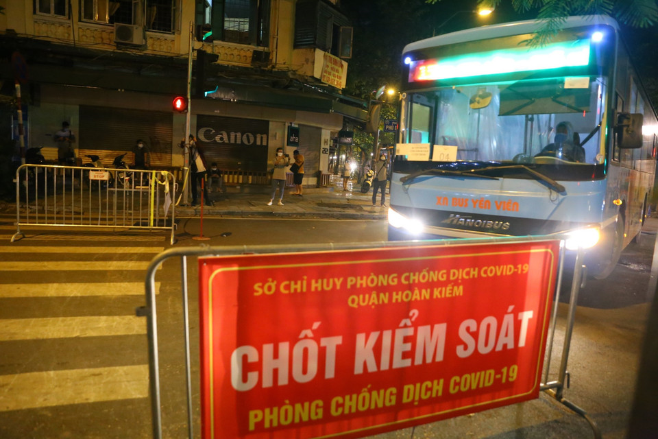 Một xe trong đoàn đón tiến vào khu vực phong tỏa phố Phủ Doãn lúc 21h40. (Ảnh: Hoàng Hiếu/TTXVN)