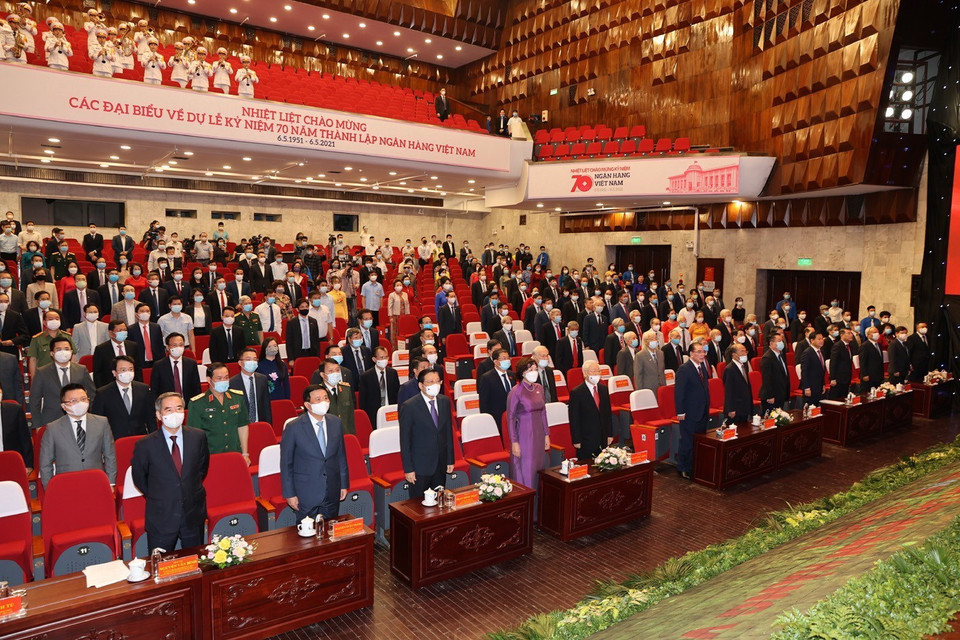 Các đồng chí lãnh đạo và nguyên lãnh đạo Đảng, Nhà nước cùng các đại biểu thực hiện nghi lễ chào cờ tại Lễ kỷ niệm. (Ảnh: Trí Dũng/TTXVN)