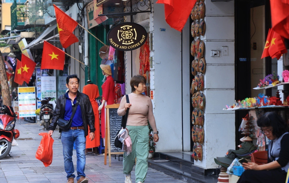 Những ngày này, du khách đắm chìm trong sắc đỏ cờ hoa trên các con phố ở Hà Nội. (Ảnh: Tuấn Anh/TTXVN)