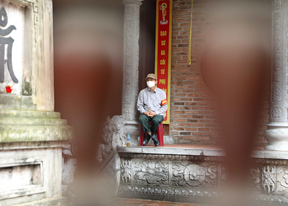 Người bảo vệ chùa Hòe Nhai trong sáng ngày Rằm tháng 3. (Ảnh: Thanh Tùng/TTXVN)