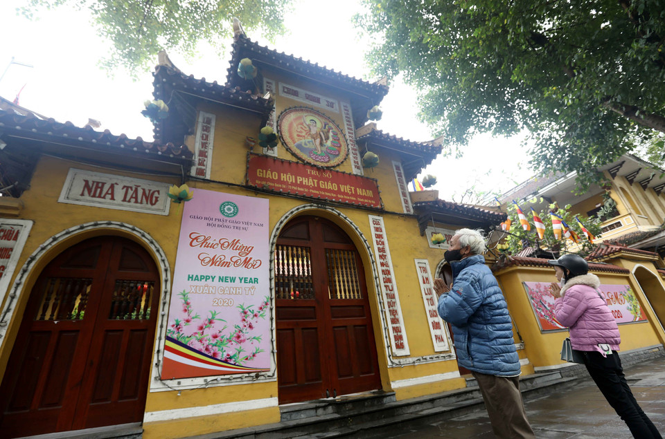 Người dân qua đường tranh thủ vái vọng bên ngoài chùa Quán Sứ trong ngày Rằm tháng 3. (Ảnh: Văn Điệp/TTXVN)