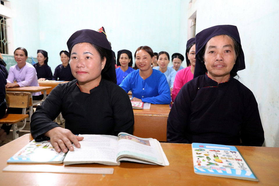 Học viên lớp xóa mù chữ tại điểm Trường Pò Mạ (thôn Pò Mạ, xã Thống Nhất, huyện biên giới Lộc Bình, tỉnh Lạng Sơn) đến lớp học mỗi buổi tối. (Ảnh: Văn Đạt/TTXVN)
