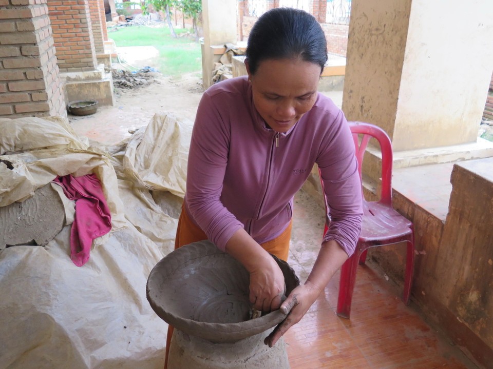 Các hoa văn trên sản phẩm gốm thể hiện nền văn hóa tín ngưỡng truyền thống của dân tộc Chăm. Trong ảnh: Tạo hình cho sản phẩm gốm bằng phương pháp truyền thống không dùng bàn xoay, hoàn toàn khác biệt so với các cách làm gốm phổ biến khác. (Ảnh: Minh Hưng/TTXVN)
