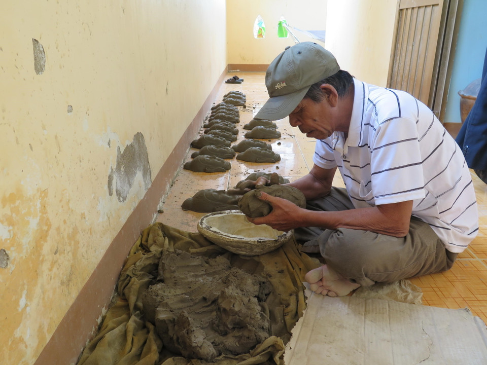 Tạo hình khuôn mặt cho một sản phẩm mỹ nghệ bằng gốm. (Ảnh: Minh Hưng/TTXVN)