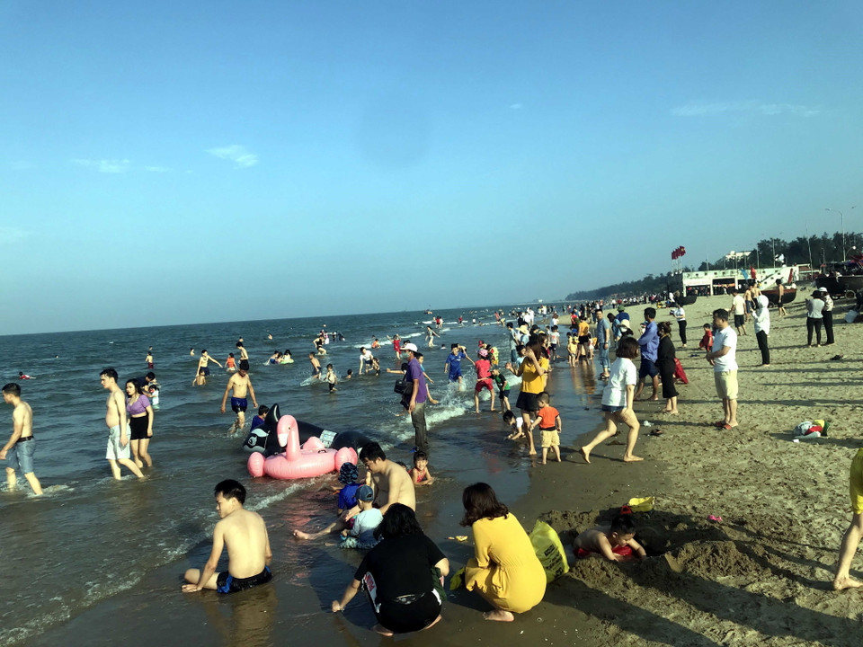 Tuy lượng khách năm nay không đông như cùng kỳ năm ngoái nhưng đây là tín hiệu đáng mừng của ngành du lịch tỉnh Nghệ An sau đợt giãn cách xã hội để phòng, chống dịch COVID-19. Trong ảnh: Du khách tắm mát và nghỉ dưỡng tại bãi biển Cửa Lò (Nghệ An). (Ảnh: Tá Chuyên/TTXVN)