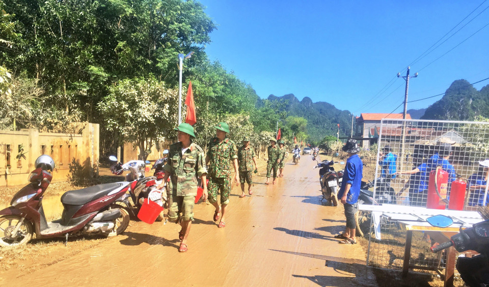 Cán bộ, chiến sỹ lực lượng vũ trang nhân dân được huy động hỗ trợ nhân dân vùng lũ Tân Hóa, huyện Minh Hóa, tỉnh Quảng Bình. (Ảnh: Võ Dung/TTXVN)