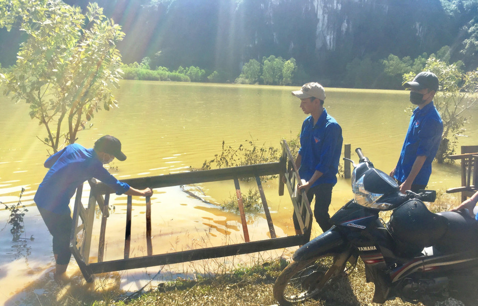 Các đoàn viên thanh niên giúp bà con nhân dân dọn dẹp vệ sinh các vật dụng sau mưa lũ. (Ảnh: Võ Dung/TTXVN)