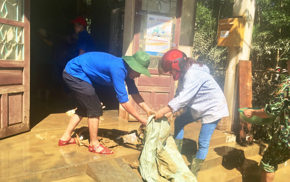 Các đoàn viên thanh niên hỗ trợ lau chùi bùn đất sau mưa lũ tại điểm bưu điện xã Tân Hóa, huyện Minh Hóa, tỉnh Quảng Bình. (Ảnh: Võ Dung/TTXVN)