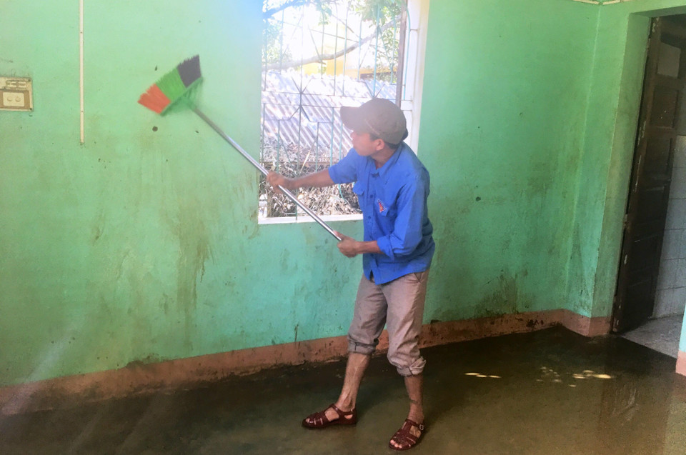 Các đoàn viên thanh niên hỗ trợ lau chùi bùn đất sau mưa lũ tại điểm bưu điện xã Tân Hóa, huyện Minh Hóa, tỉnh Quảng Bình. (Ảnh: Võ Dung/TTXVN)