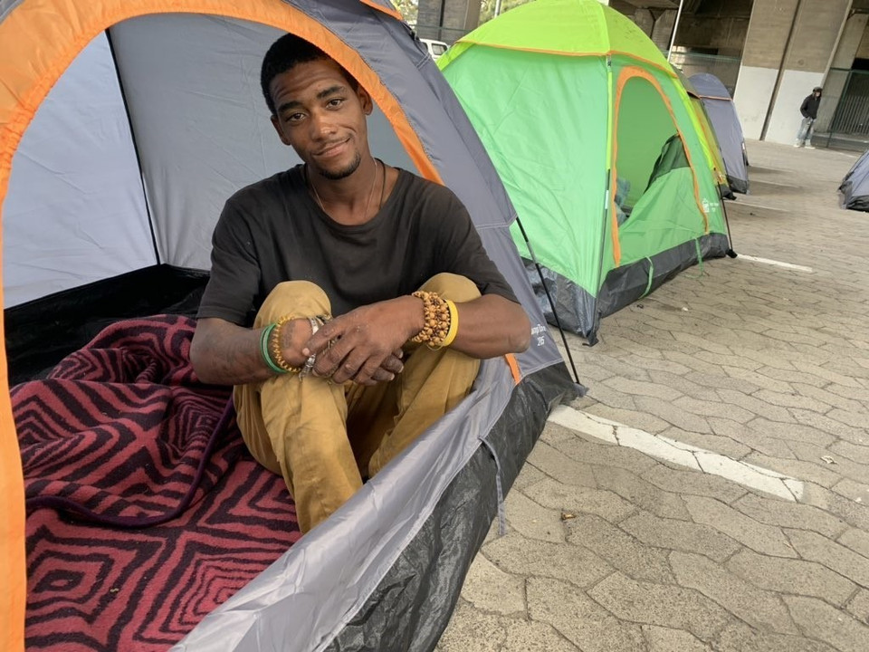 Đa số những người vô gia cư hoan nghênh chủ trương trên vì nhờ đó họ đã có những ngày được sống trong chăn ấm đệm êm cùng những bữa ăn ngon miệng. Trong ảnh: Một thanh nhiên vô gia cư nghỉ ngơi trong chiếc lều do chính phủ cung cấp. (Ảnh: Phi Hùng/TTXVN)