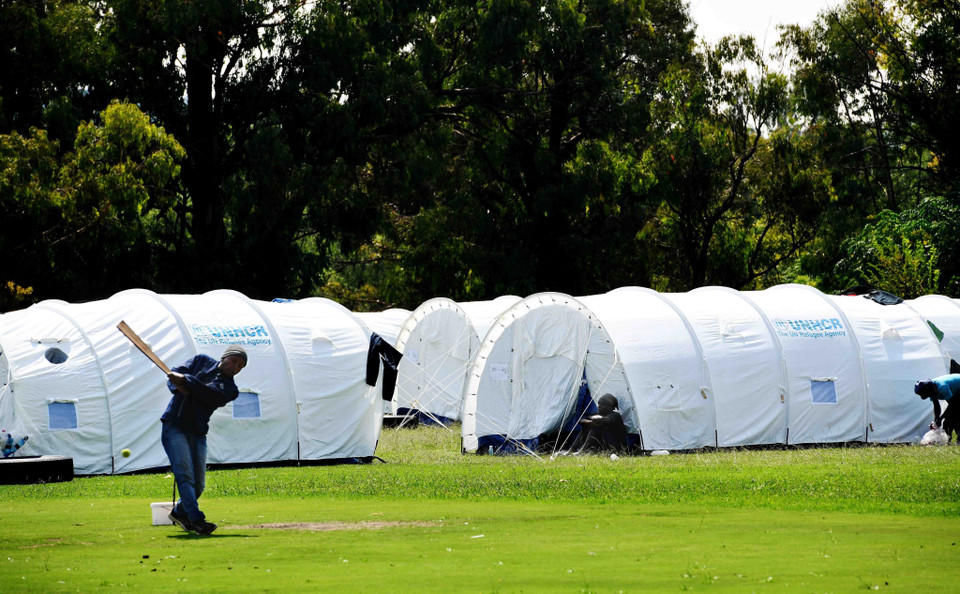 Một người vô gia cư tranh thủ chơi môn bóng chày tại một khu nhà tạm dành cho người không nhà cửa tại thủ đô Pretoria. (Ảnh: Phi Hùng/TTXVN)
