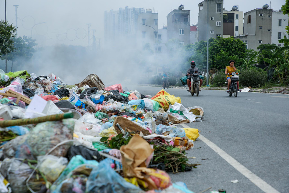 Trên con đường trải nhựa rộng cả chục mét, một nửa đã bị chiếm dụng với mục đích để rác thải sinh hoạt và nhiều chất thải dạng cao su, vải vụn khác từ làng nghề gần đó. (Ảnh: Minh Sơn/Vietnam+)