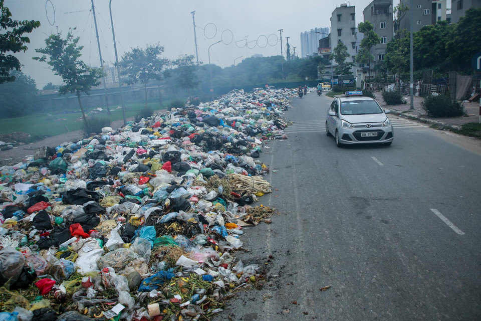 Các phương tiện buộc phải đi trái phần đường chỉ vì... rác (Ảnh: Minh Sơn/Vietnam+)
