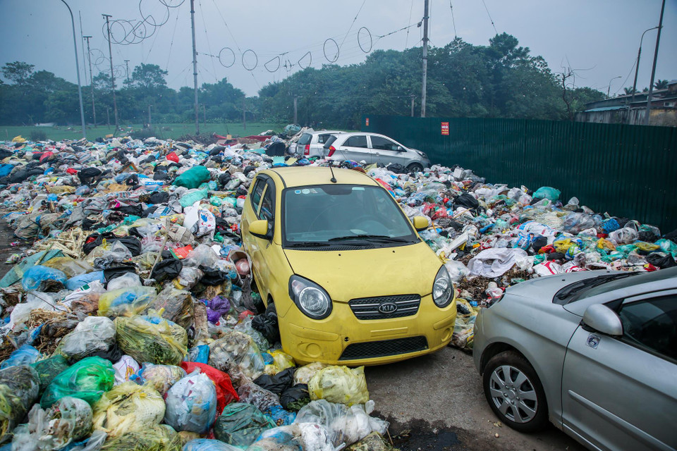 Đến cả những chiếc xế hộp cũng không thoát khỏi cảnh ‘sống chung với rác’. (Ảnh: Minh Sơn/Vietnam+)