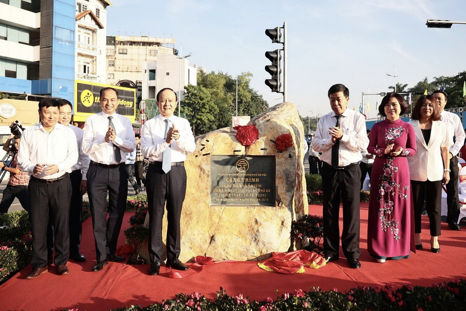 Các đại biểu thực hiện nghi thức gắn biển công trình kỷ niệm 70 năm Ngày Giải phóng Thủ đô. (Ảnh: Trung Nguyên/TTXVN)