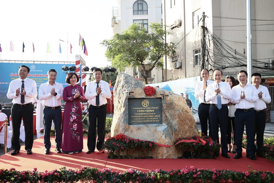 Lãnh đạo Ủy ban Nhân dân thành phố Hà Nội và các đại biểu thực hiện nghi thức gắn biển công trình chào mừng kỷ niệm 70 năm Ngày Giải phóng Thủ đô cho tuyến đường Nghi Tàm-Âu Cơ. (Ảnh: Trung Nguyên/TTXVN)