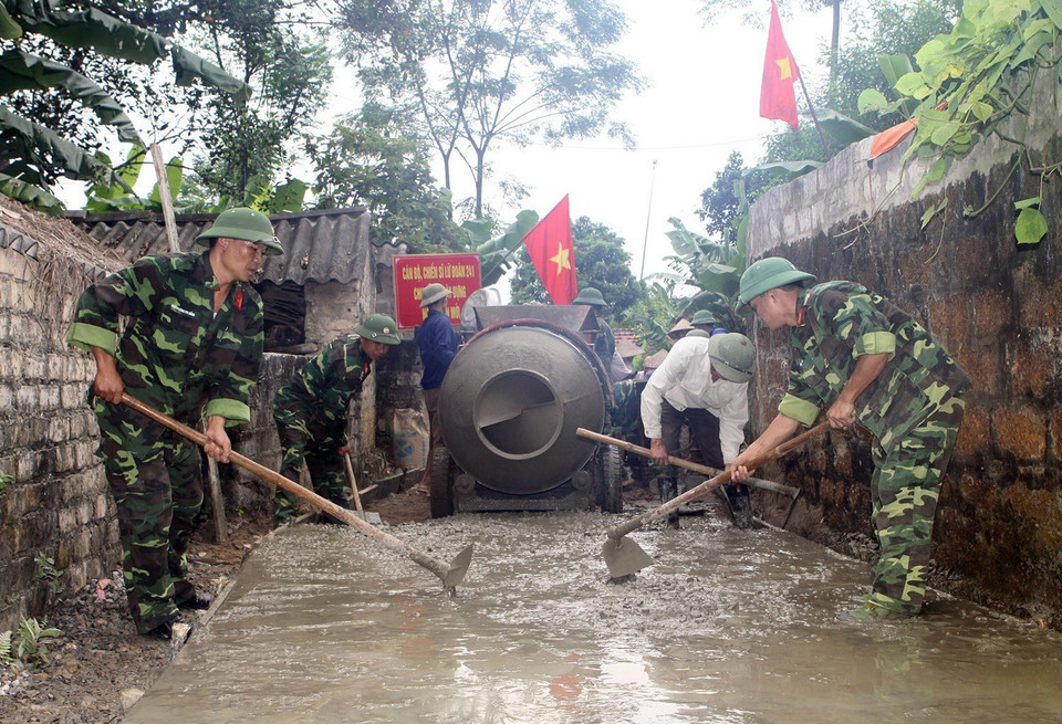 Quân đội tích cực tham gia phong trào xây dựng nông thôn mới một cách hiệu quả, thiết thực, phù hợp với đặc điểm, tổ chức, chức năng, nhiệm vụ của quân đội. Trong ảnh: Cán bộ, chiến sỹ Lữ đoàn pháo binh 241 đổ bêtông đường làng, ngõ xóm tại thôn Xanh, xã Quỳnh Lưu, huyện Nho Quan, tỉnh Ninh Bình. (Ảnh: Trọng Đức/TTXVN)