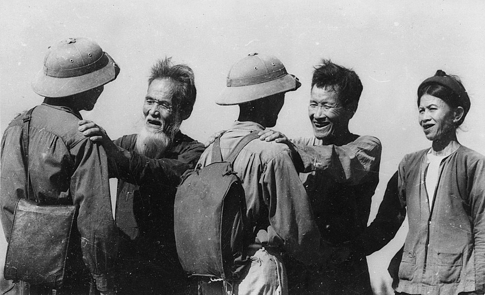 Cụ Nguyễn Danh Mai (trái) và cụ Hoàng Phi Sơn, ở xã Diễn Minh, huyện Diễn Châu (Nghệ An), đều có ba con tòng quân, nay lại tiễn người con thứ tư lên đường nhập ngũ kháng chiến chống Mỹ, cứu nước, tháng 8/1964, sau khi Mỹ mở rộng đánh phá bằng không quân ra miền Bắc. (Ảnh: Nguyễn Chính/TTXVN)