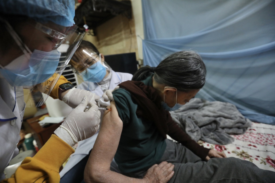 Nhân viên y tế phường Điện Biên, quận Ba Đình đến tận nhà tiêm vaccine phòng COVID-19 cho người cao tuổi. (Ảnh: Minh Quyết/TTXVN)