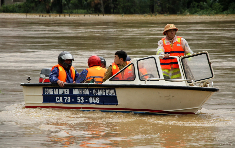 Công an huyện Minh Hóa, tỉnh Quảng Bình đưa người dân và tài sản đến vùng an toàn. (Ảnh: Văn Tý/TTXVN)