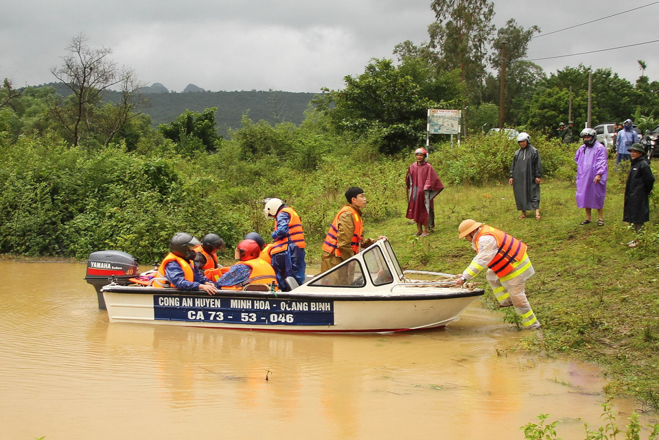 Công an huyện Minh Hóa, tỉnh Quảng Bình đưa người dân và tài sản đến vùng an toàn. (Ảnh: Văn Tý/TTXVN)