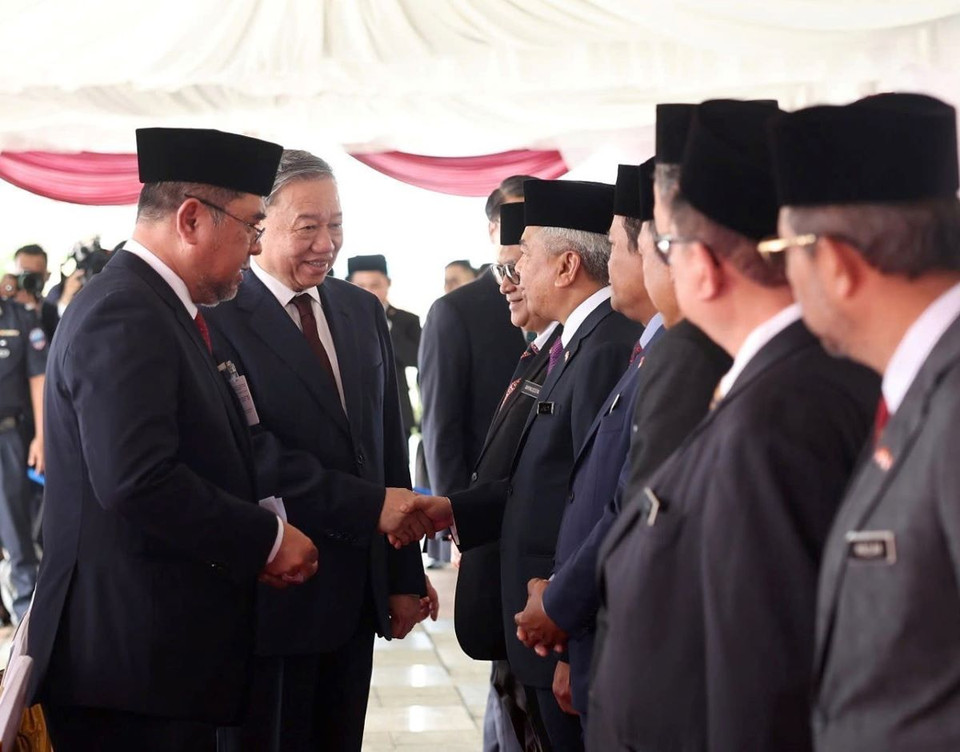 Tổng Bí thư Tô Lâm bắt tay các thành viên đoàn Malaysia tại lễ đón. (Ảnh: Thống Nhất/TTXVN)